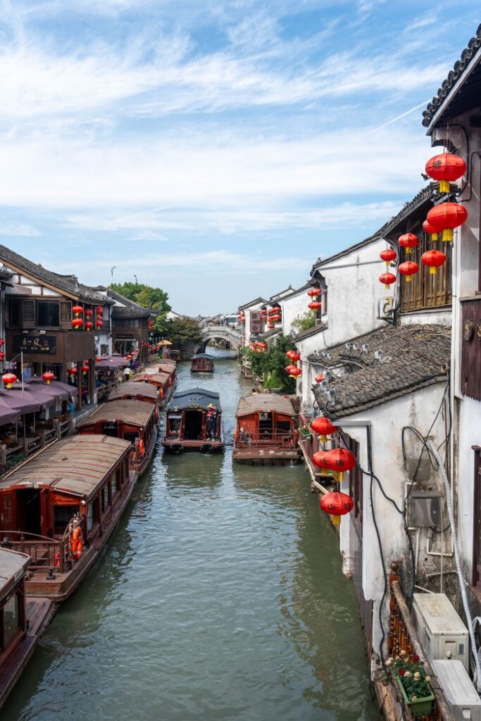 Charming water town scene with boats and red lanterns lining the canal in China.